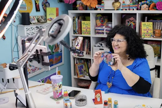 一位業餘愛好者正透過智慧型手機直播，展示自己的手工藝作品